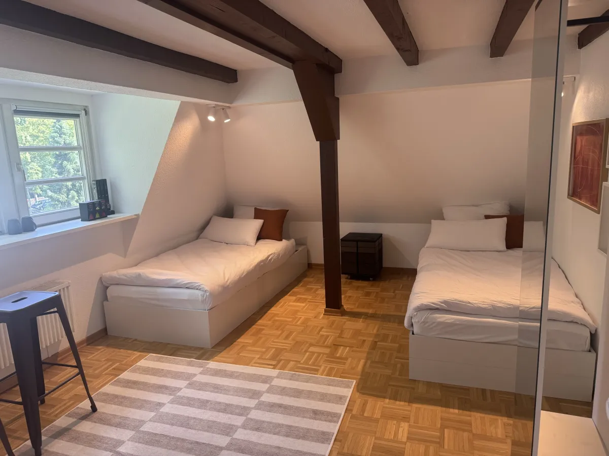 Twin bedroom with wooden beams and parquet floor