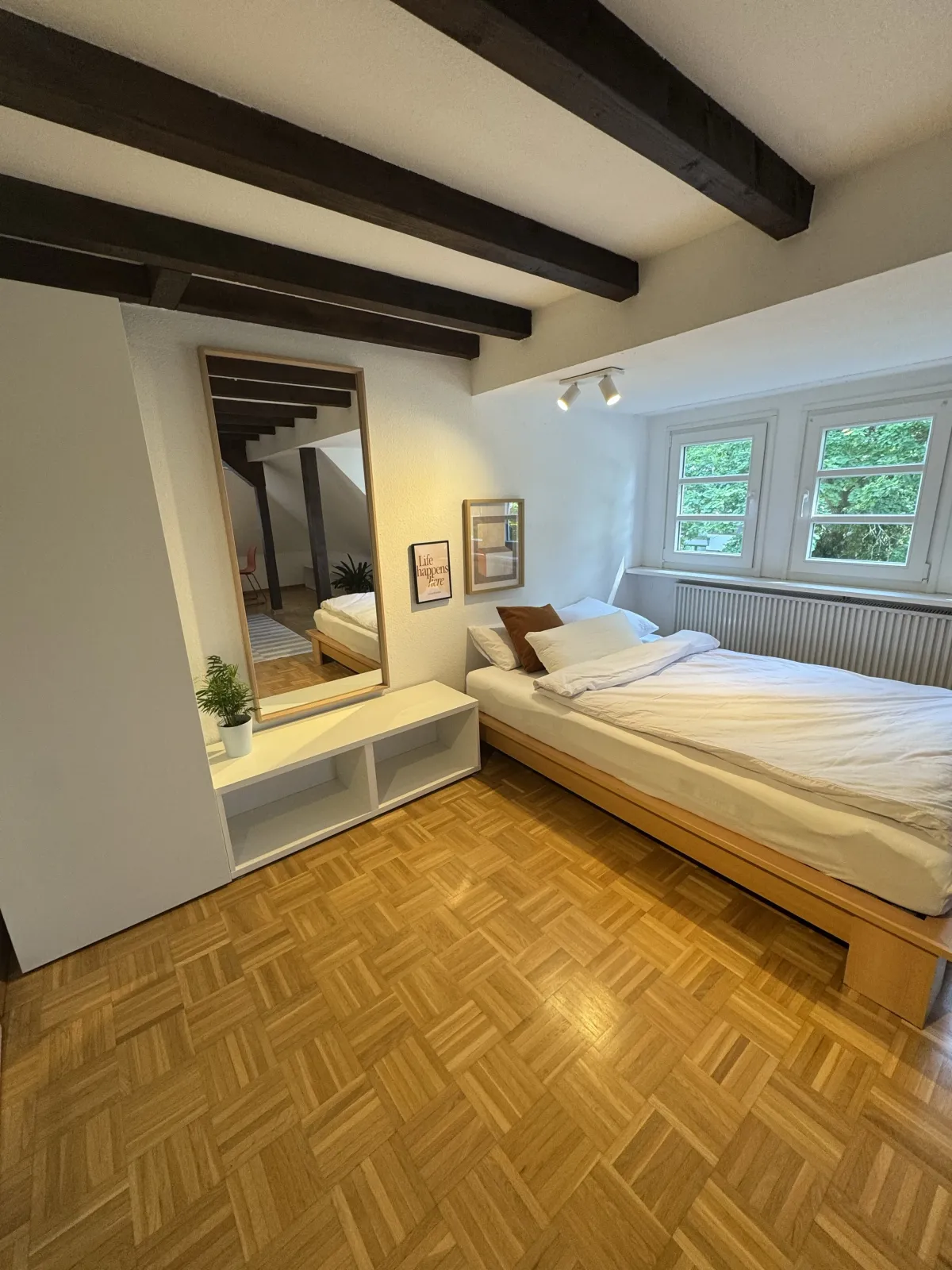 Double bedroom with floor mirror and garden view