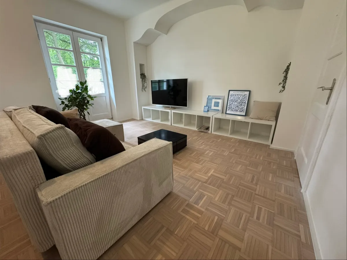Living room with corner sofa, TV and door to garden terrace