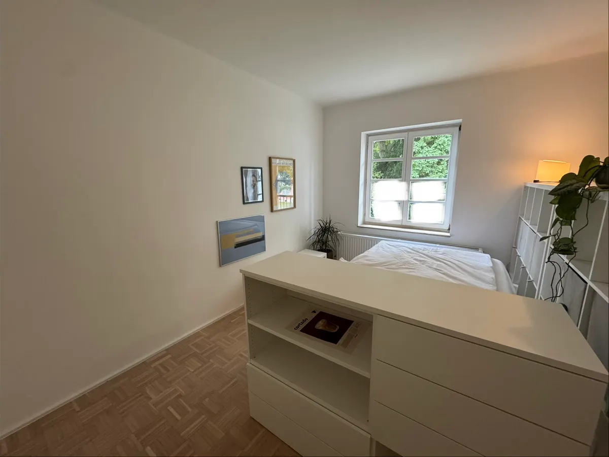 Double bedroom nook with dresser and garden-view window