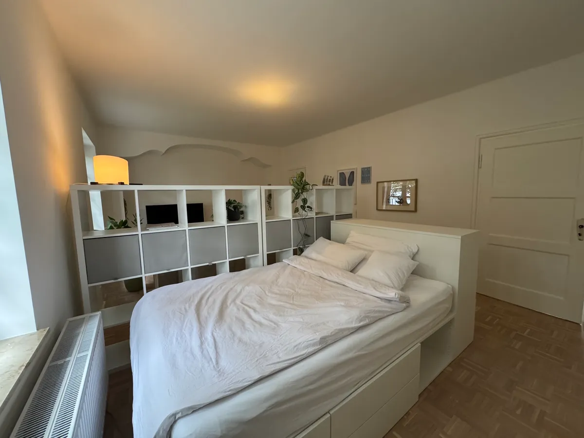 Single bedroom nook with bedside shelving and artwork