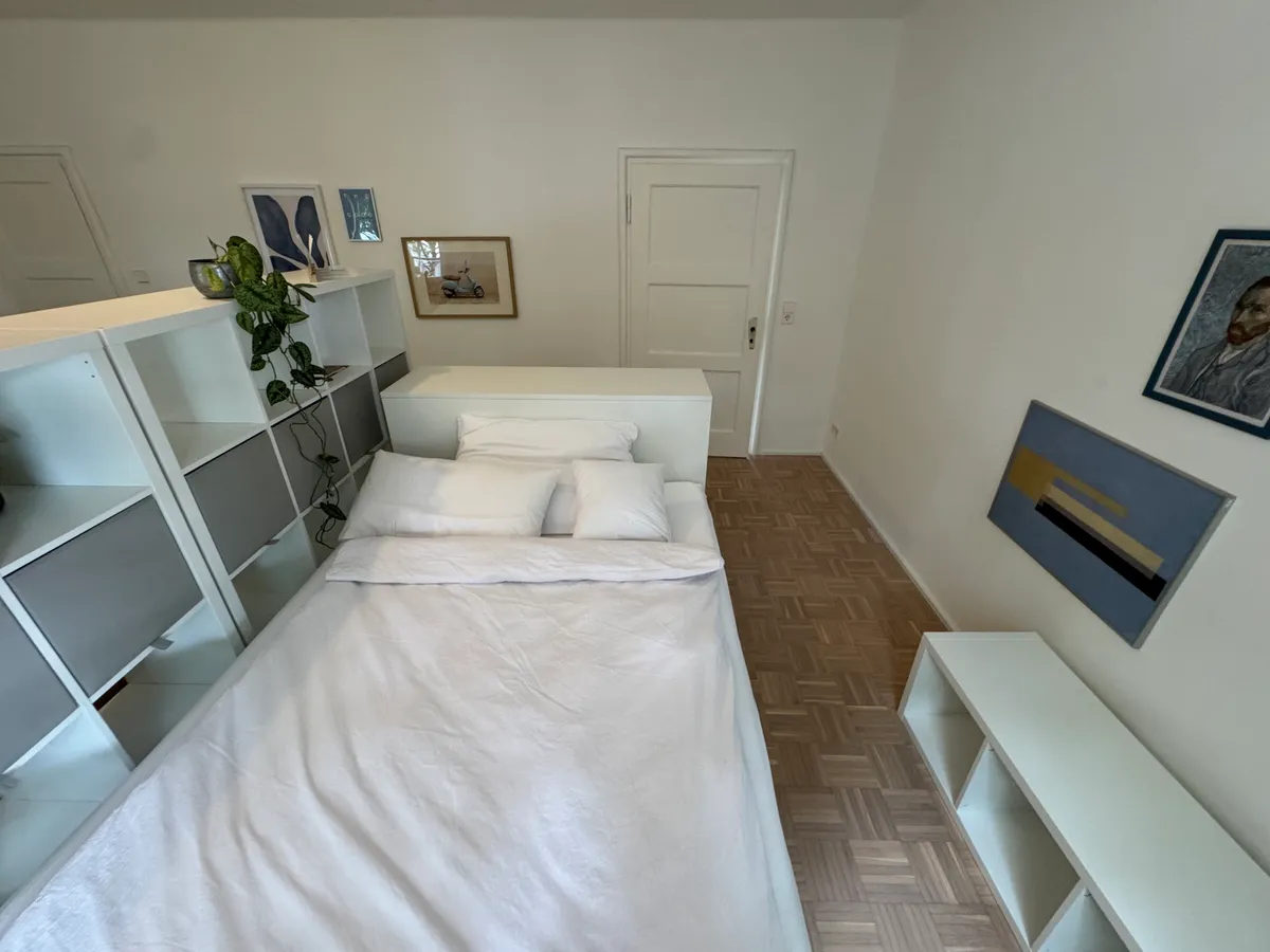 Single bed with room-divider shelving and desk