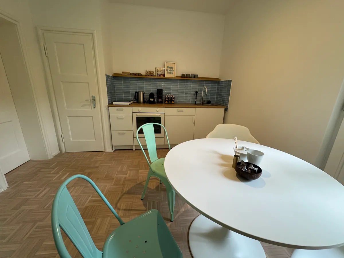 Kitchen with dining table and blue tile splashback