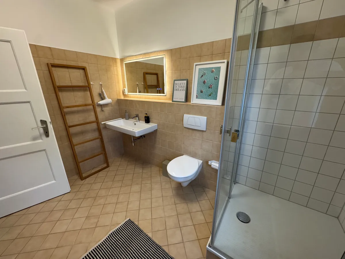 Bathroom with walk-in shower, sink and heated towel rack